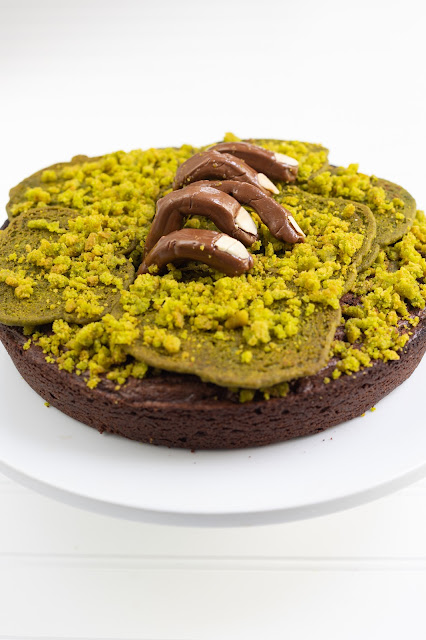 Zombie Brownie Cake. A brownie with green sugar cookies/crumbles on top to look like grass/moss. Tootsie rolls shaped like fingers appear to crawl out of the brownie/cake.