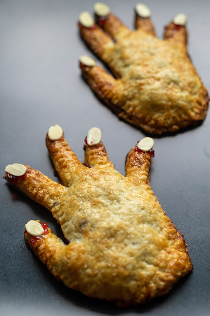 Cooked sweet Halloween Hand Pies shaped like a hand with almond slivers for fingernails.