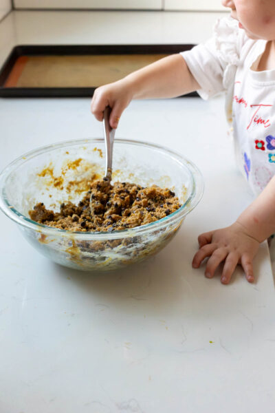 Little girl mixes dough for chocolate chip cookies that will be turned into ice cream sandwich cookies