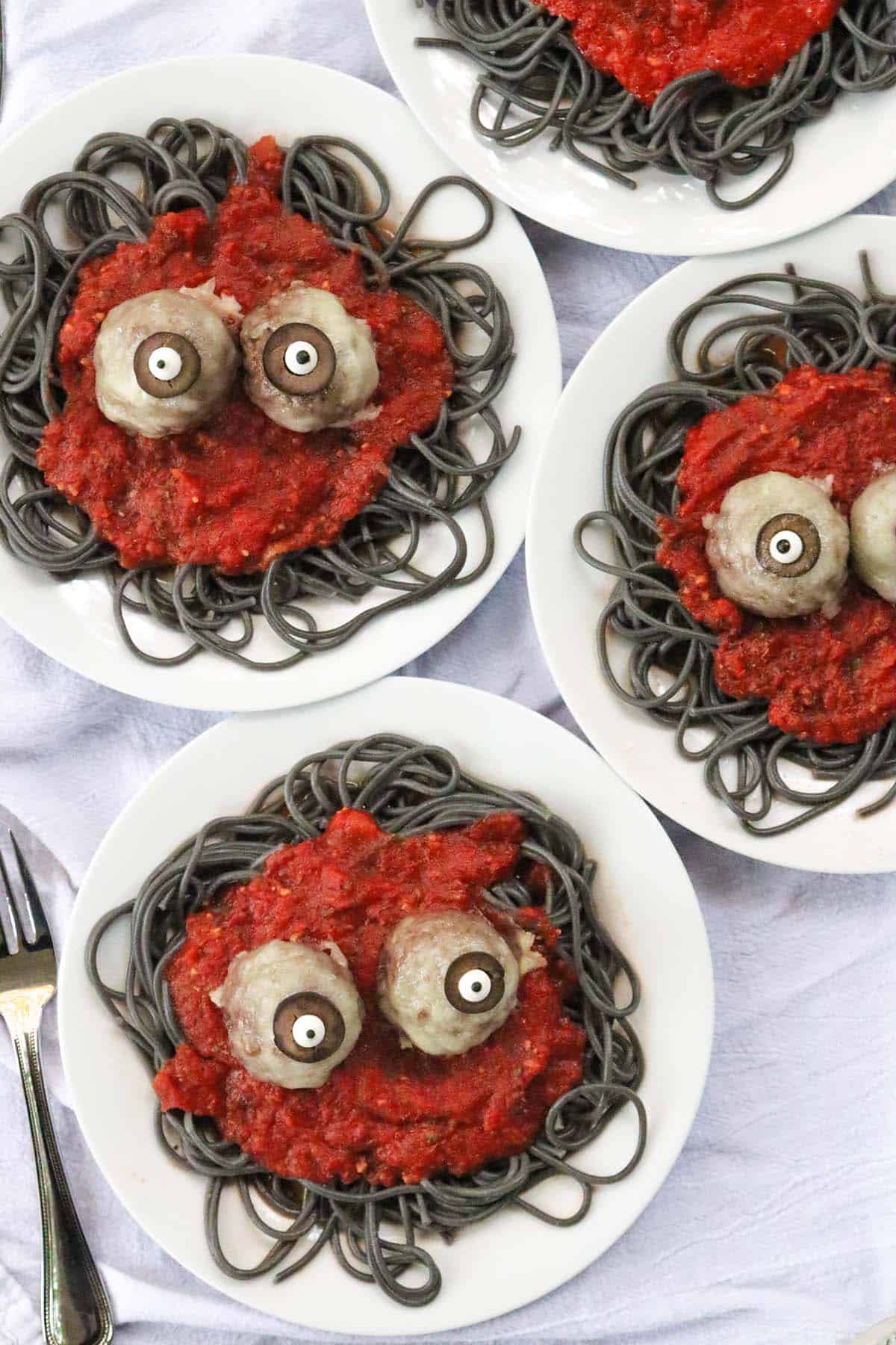 spaghetti-and-meatball-eyeballs-featured-1 Spaghetti and meatball eyeballs plated over black squid ink pasta with red marinara sauce for Halloween dinner